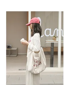 Détail d'un grand sac cabas en toile crème avec un imprimé C'est à vous rouge bordeaux