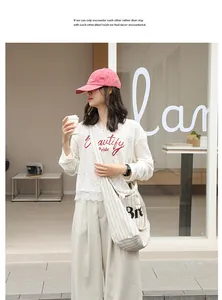 Lifestyle view of a striped cotton linen tote bag worn by a model in a cafe setting.