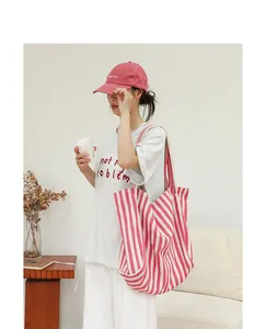 Vista de estilo de vida de un gran bolso tote de lona a rayas rosas y blancas para mujer