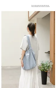 Vista posterior de una modelo con un bolso tote de lona con lunares azules en un entorno sobrio