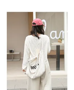 Lifestyle back view of a minimalist casual striped canvas tote bag with 'bread' letter print