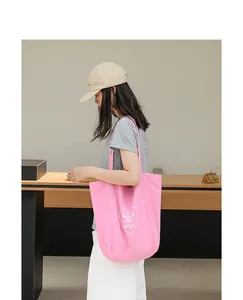 Bolso tote de nailon rosa con estampado de corazón 'Have a nice day' en modelo.