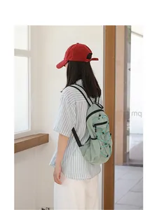 Asian woman wearing a casual light green checkered nylon backpack in a bright indoor setting