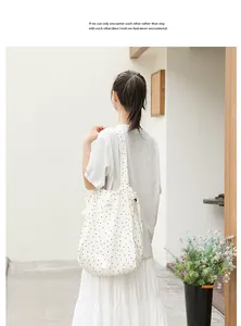 Foto lifestyle de bolso tote de lona con lunares blancos y cierre de cordón