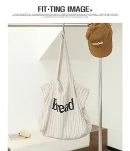 Detail view of a minimalist striped canvas tote bag featuring Bread letter print.