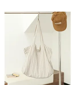 Casual striped cotton linen tote bag hanging on a minimalist metal rack
