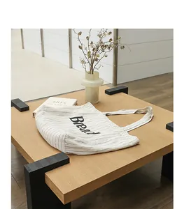 Detail of cotton linen striped canvas tote bag with 'Bread' print on a table