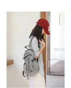 Side view of gray checkered nylon backpack featuring stylish drawstring detailing and pleats