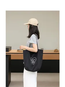 Bolso tote de nailon negro casual con estampado de corazón, mostrado en una modelo de perfil.
