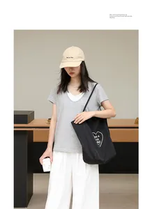 Primer plano de un bolso tote de nailon negro con estampado de corazón estilo vida