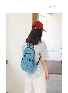 Lifestyle shot of a model wearing a blue grid nylon backpack with adjustable drawstrings