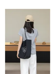 Vista posterior de una modelo con bolso tote de nailon negro y un detalle de corazón