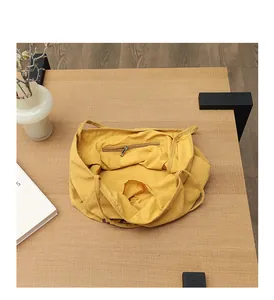 Vue détaillée de la poche zippée et du compartiment intérieur d'un sac cabas en lin jaune
