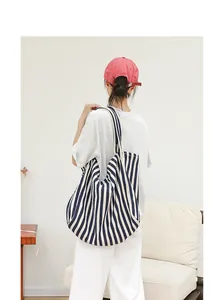Bolso tote de lona a rayas azules y blancas de gran capacidad para mujer en un hogar