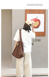 Bolso tote de lona marrón con lunares y cordón, mostrado por una modelo en la calle.