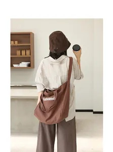 Detail view of a brown linen tote bag with Salomé print styled with a bucket hat.