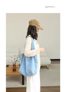 Stylish blue drawstring pleated tote bag for women shown in a lifestyle setting