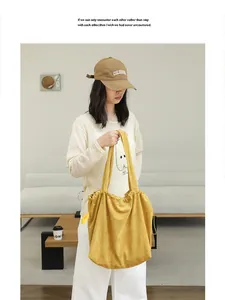 Yellow suede-like drawstring tote bag shown in a lifestyle setting carried by a model.