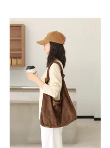 Vista ravvicinata della borsa a tracolla minimalista in pelle scamosciata marrone con nodo.