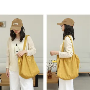 Asian model showcasing a mustard yellow suede drawstring tote bag in a lifestyle setting