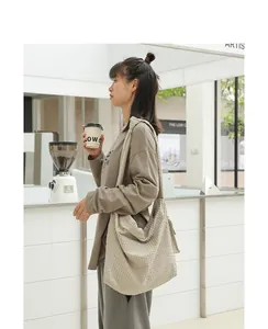Large beige checkered nylon hobo bag for women in a casual cafe lifestyle setting