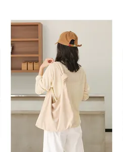 Vista posteriore di una borsa a tracolla beige in finta pelle scamosciata