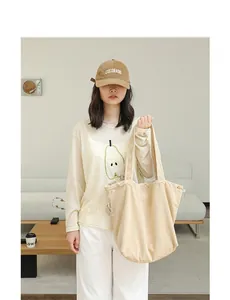 Lifestyle view of a beige suede drawstring tote bag with casual Japanese styling.