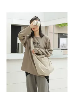 Casual beige checkered nylon messenger bag worn by a model in an outdoor setting