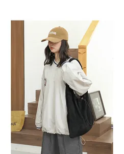 Lifestyle view of a casual black suede drawstring shoulder bag worn by a model