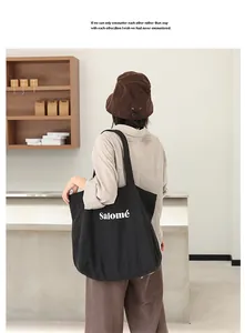 Model showing the large black linen tote bag with Salomé print from the back view