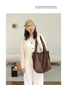 Stylish brown suede drawstring tote bag with pleated detail for a minimalist casual look.
