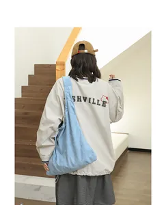 Back view of a woman carrying a light blue suede slouchy shoulder bag with drawstring detail