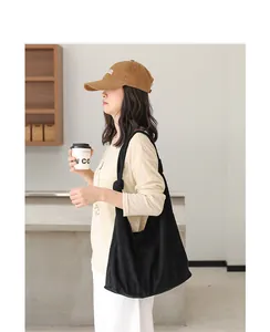 Dettaglio della borsa hobo nera con nodo minimalista che mostra la morbida trama in pelle