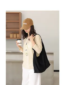 Vista lifestyle di una grande borsa a tracolla nera minimalista in finta pelle