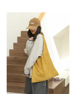 Lifestyle view of a stylish yellow drawstring shoulder bag in soft suede-like fabric material