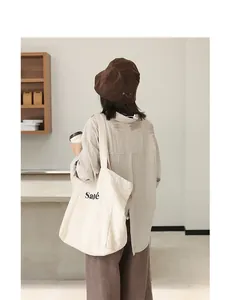Minimalist Japanese style linen tote bag with letter print shown in a lifestyle setting