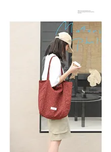 Lifestyle view of woman carrying a red polka dot nylon tote bag in a street setting