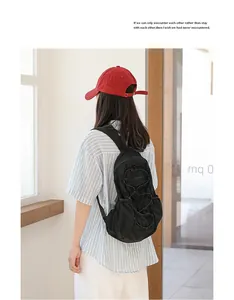 Back view of a stylish black nylon pleated backpack with adjustable drawstring details