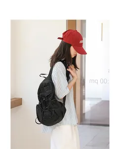 Japanese style casual black nylon drawstring backpack with pleated detail worn by model