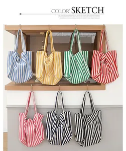 Colección de bolsos tote de lona a rayas de colores colgados en un ambiente minimalista
