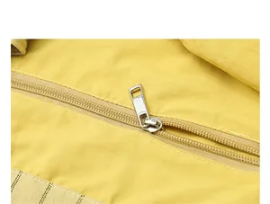 Close-up detail of high-quality metal zipper on a yellow striped canvas tote