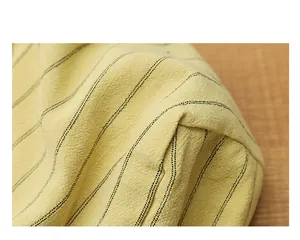 Detailed macro shot showing the striped cotton linen fabric texture of the yellow tote bag