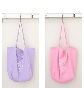Vista detallada de bolsos tote de nailon rosa y morado con estampado corazón nice day
