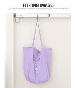 Detalle de un bolso tote de nailon morado con estampado de corazón blanco en un riel