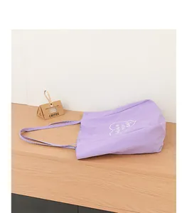 Bolso tote de nailon morado informal con estampado de corazón blanco en un escritorio