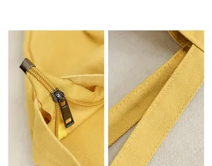 Dettaglio della cerniera nera e dei manici di una borsa tote in tela gialla vivace