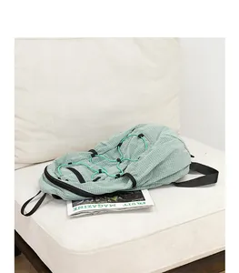 Detailed view of a light green checkered nylon backpack featuring decorative drawstrings