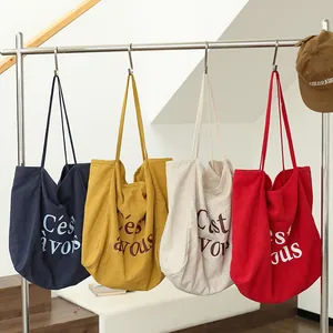 Collection de sacs cabas en lin colorés avec impression 'C'est vous' sur un support