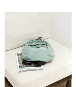 Casual light green checkered nylon backpack resting on a soft white fabric sofa