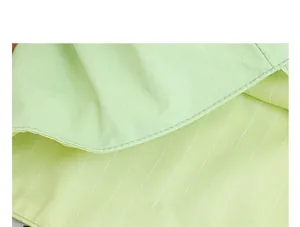 Detalle de un bolso de nailon verde claro con forro de rayas y costuras de calidad